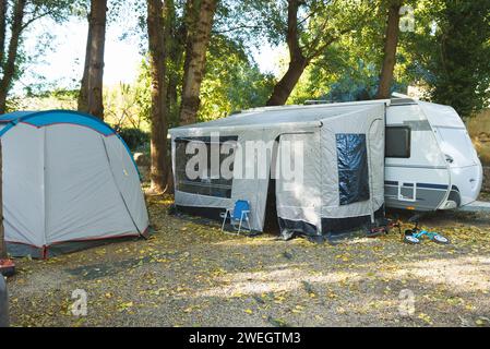 Tents setup for a group camping at the green grass meadow. Multiple blue instant up connectable tents on a campground. Stock Photo