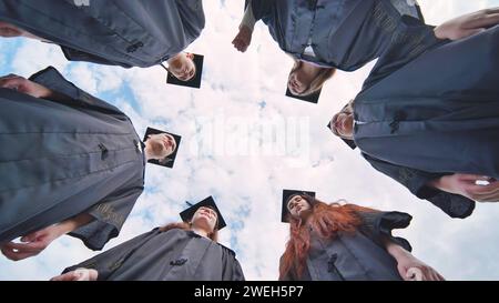 College students stand in a circle wearing black robes. Stock Photo