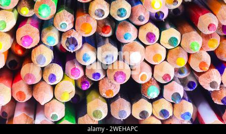 many tips of coloring pencils with freshly sharpened tips ideal as a school background Stock Photo
