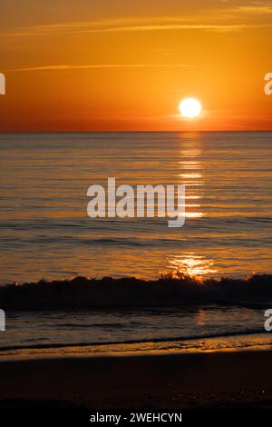 Waves gently lapping the shore at sunrise, Gordons Pond, Cape Henlopen State Park, Delaware Stock Photo