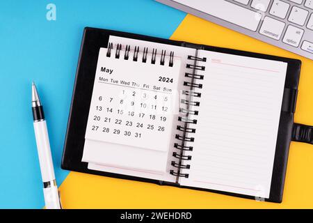 May 2024 calendar, notepad, pen and computer keyboard Stock Photo