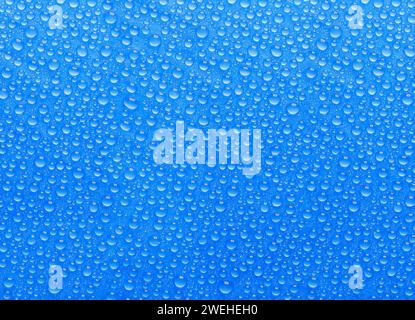 many small blue drops of water on a blue surface Stock Photo