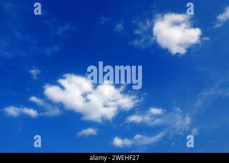 two white fair weather clouds, cumulus in the blue sky Stock Photo