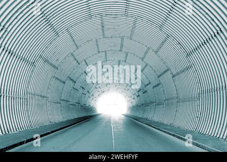 Interior view of a tunnel with bright tunnel exit, light at the end of the tunnel Stock Photo