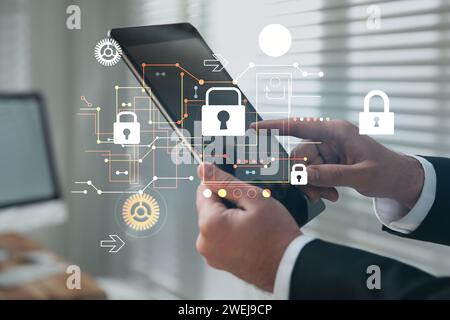 Privacy protection. Man using tablet in office, closeup. Digital scheme with padlocks over device Stock Photo