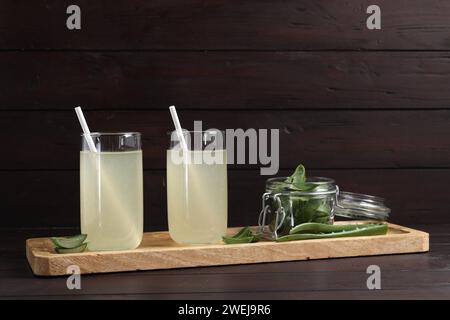 Tasty aloe juice in glasses and cut fresh leaves on wooden table Stock Photo