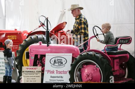 Abbotsford, Canada. 25th Jan, 2024. Visitors look at a vintage tractor during the Pacific Agriculture Show in Abbotsford, British Columbia, Canada, on Jan. 25, 2024. The 26th annual Pacific Agricultural Show runs from Jan. 25 to 27 in Abbotsford, Canada. More than 300 exhibitors showcase the latest equipment and technology for the agriculture industry, attracting thousands of farmers and producers. Credit: Liang Sen/Xinhua/Alamy Live News Stock Photo