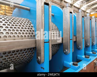 Twin screw press for pressing of animal and fish byproducts, shown with covers off and screens visible. Stock Photo