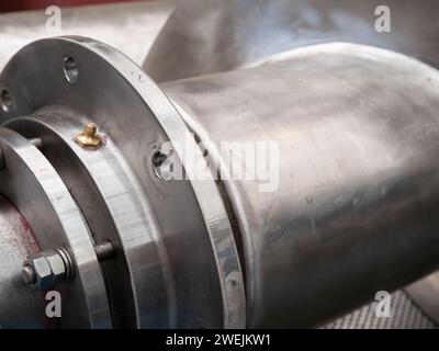 Closeup of drive shaft, flange, grease nipple and screw of a twin screw press for pressing of animal and fish byproducts. Stock Photo