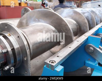 Closeup of drive shaft, flange, grease nipple and screw of a twin screw press for pressing of animal and fish byproducts. Stock Photo