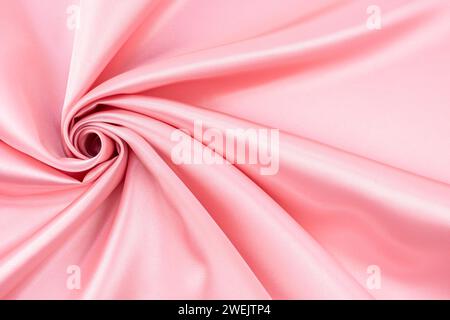 Pink color satin crumpled or wavy fabric texture background. Abstract satin cloth soft waves. Stock Photo