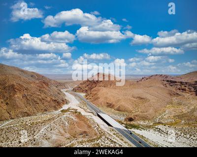 Empty road winding through desert mountains in the heart of arid wilderness Stock Photo