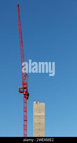 Portrait image of the concrete core tower & tower crane on a sunny day during construction of One Victoria residential development in Manchester, UK Stock Photo