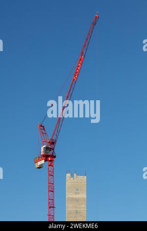 Portrait image of the concrete core tower & tower crane on a sunny day during construction of One Victoria residential development in Manchester, UK Stock Photo