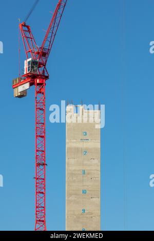 Portrait image of the concrete core tower & tower crane on a sunny day during construction of One Victoria residential development in Manchester, UK Stock Photo