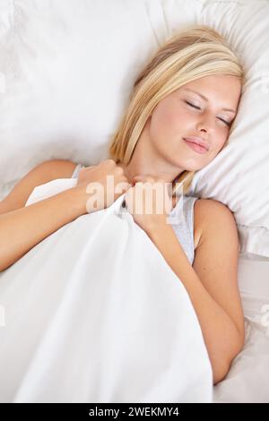 Sleeping, peace and tired woman in a bed resting, dreaming and comfortable at home from above. Eyes closed, face and person asleep in a bedroom with Stock Photo