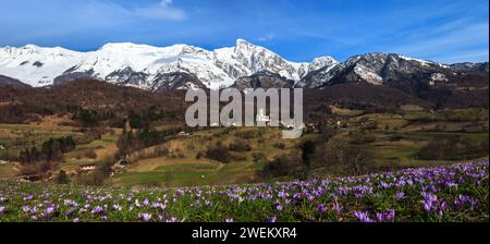 Church Of The Sacred Heart In Dreznica - Kobarid in Springtime with Flowers and Snow Panorama with Julian Alps Stock Photo