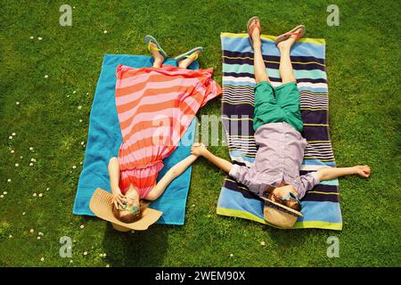 Boy and Girl Sunbathing on Lawn Stock Photo