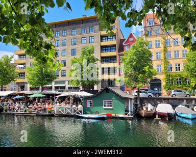 People enjoying lunch on a restaurant terrace by the water in Christianshavn Canal, Copenhagen, Denmark Stock Photo