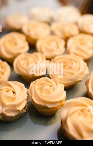Close up of vanilla cupcakes with frosting arranged on table Stock Photo