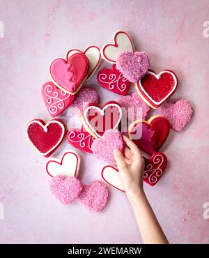 Child sneaking heart shaped cookie Stock Photo