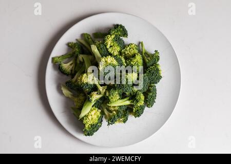 looking down on plate of fresh broccoli with white background Stock Photo