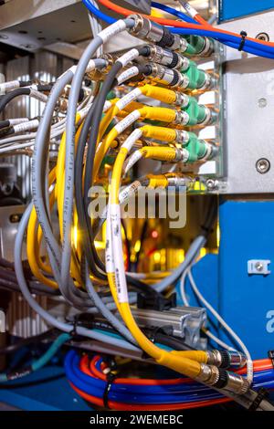 Numerous cables plugged into electronic machine Stock Photo