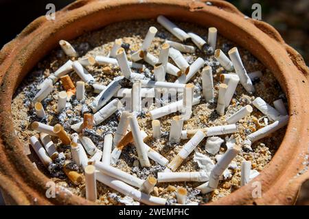 The many cigarette butts in the potted plant Stock Photo