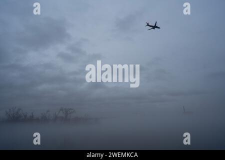 Washington, USA. 26th Jan, 2024. This photo taken on Jan. 25, 2024 from Arlington, Virginia shows an airplane flying over the Washington Monument shrouded in fog in Washington, DC, the United States. Credit: Liu Jie/Xinhua/Alamy Live News Stock Photo