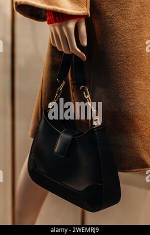 Classic black leather women's handbag with gold chain. Fashion details Stock Photo