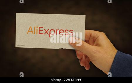 Poznan, Poland, January 25, 2024: AliExpress Alibaba group online retail box in hand. E-business chinese company. Cardboard pack factory. Abstract con Stock Photo