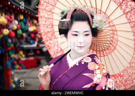 Beautiful Japanese Geisha Maiko in Kyoto, Japan with umbrella Stock Photo