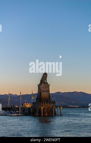 Lindau on Lake Constance, entrance to the harbour, Bavarian lion, pier, motorboats, view of the Alps, half moon, evening light, Bavaria, Germany Stock Photo