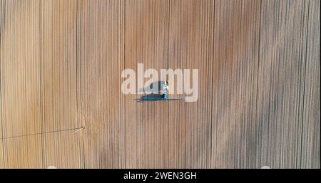 Agricultural - Tractor working in field Drone view. Stock Photo