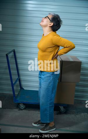 Back hurts after transporting things in cardboard boxes Stock Photo