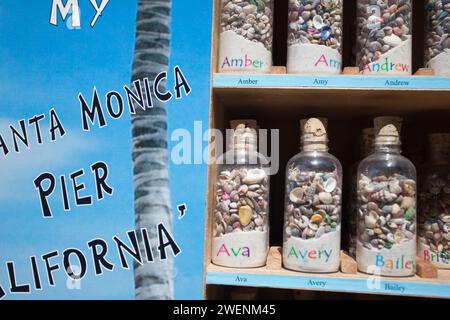 souvenir bottles of pebbles with names on each bottle on display on Santa Monica pier for tourists to purchase Stock Photo