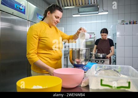 Team of pastry chefs are working together in bakery kitchen Stock Photo