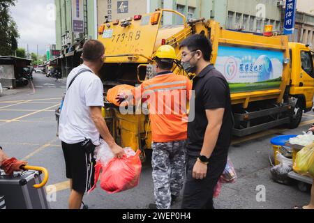 Yilan, Republic of China - October 2, 2023: A garbage truck and binmen on the streets of Yilan, Taiwan providing waste removal. Stock Photo