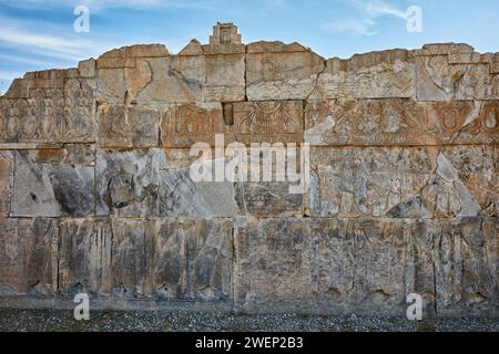 Badly damaged reliefs on a platform of a ruined building in Persepolis, capital of the Achaemenid Empire (550–330 BC), Iran. Stock Photo