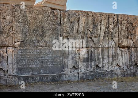 Badly damaged reliefs and cuneiform inscriptions on platform of ruined building in Persepolis, capital of the Achaemenid Empire (550–330 BC), Iran. Stock Photo
