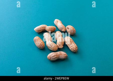 pile of peanuts in pods on green background Stock Photo