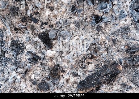 Coal, ash and cinders on a flat surface, all that is left of firewood. For use as an abstract background and texture. Stock Photo
