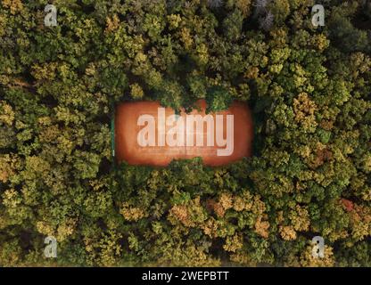 Tennis court in the forest from aerial top view. Stock Photo