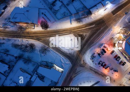 Traffic junction in a snowy night city from aerial top view. Stock Photo