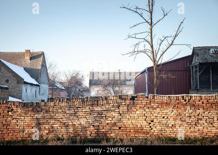 Picture of a decaying wall made of red bricks in an half abandoned village of serbia in the norther province of vojvodina. Stock Photo