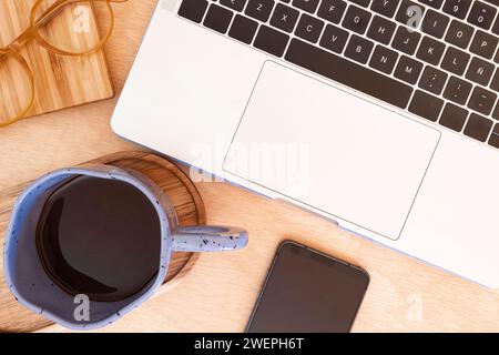 Mug placed beside computer on desk Stock Photo