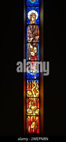 The Virgin of Carmel and Jesus hand the scapular to souls in Purgatory. A stained-glass window in Igreja de Nossa Senhora de Fátima, Lisbon. Stock Photo