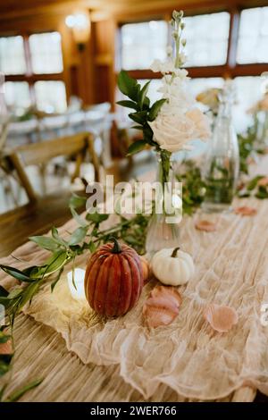 A fall tablescape decor adorned with white flowers and pumpkins Stock Photo