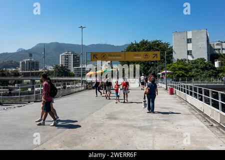 Pedestrians walking on the footbridge that links Maracana train station to Maracana stadium and the State University (UERJ) under summer blue sky. Stock Photo