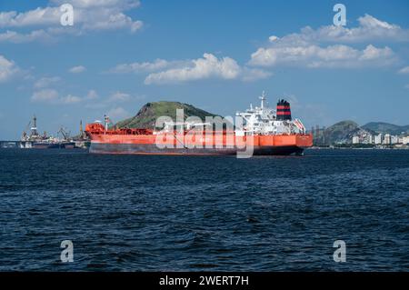 Big crude oil tanker Tordis Knutsen ship anchored on Guanabara bay blue waters with Morro da Penha hill at back under summer afternoon sunny blue sky. Stock Photo